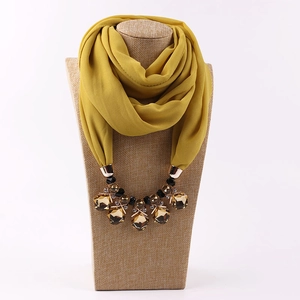 Close-up of ginger chiffon scarf necklace featuring amber crystal and metallic details