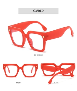 Detail view of red square frame glasses with golden decorative vertical stripes
