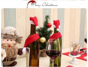 Close-up of red and white mini Christmas hats and scarves set decorating wine bottles