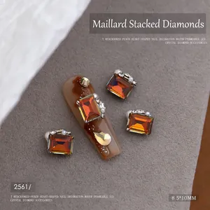 Detail van amberkleurige kristallen nagelbedeltjes met parels en metalen basis