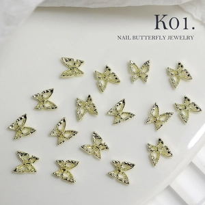 Macro view of gold alloy 3D hollow butterfly nail charms with textured metallic wings