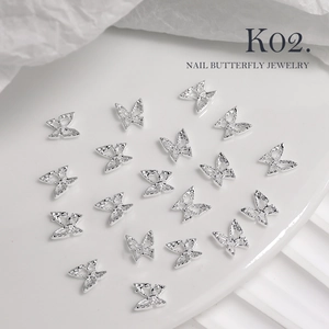 Macro detail of silver 3D bow-knot butterfly nail charms with hollow texture for manicure