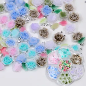 Detalle macro de dijes para uñas de resina de rosa y hoja en caja floral
