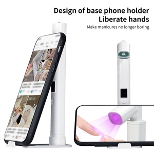 Close-up of portable UV nail lamp with integrated phone holder for multitasking