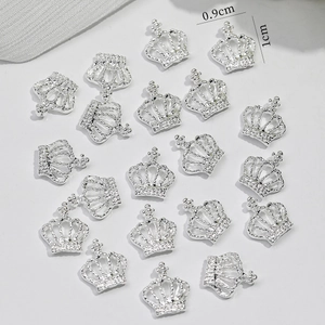 Macro shot of silver crown alloy nail art charms with hollow texture and size labels