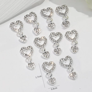 Macro detail of silver heart pendants with rhinestones measuring 1.7cm by 0.8cm