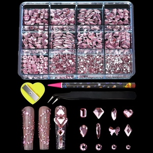 Macro detail of 12-slot nail art kit with pink rhinestones, tweezers and dotting tools