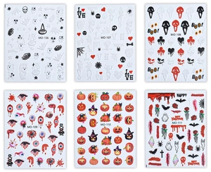 Detailed macro view of 3D Halloween nail stickers with pink pumpkins and skulls