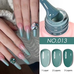 Macro shot showing ice-translucent blue-grey nail gel with layered coverage and rhinestones