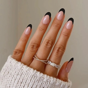 Faux ongles amande courts avec pointes French noires et finition nude rose brillant