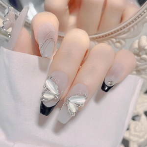 Vue détaillée d'ongles ballerine avec papillons en œil de chat 3D et accents de strass