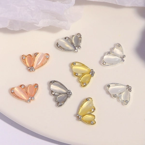 Vue détaillée de breloques papillon pour ongles avec pierres œil-de-chat et strass brillants