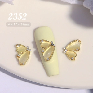 Détail du bijou d'ongle papillon doré 12,4x14mm avec effet œil de chat et strass