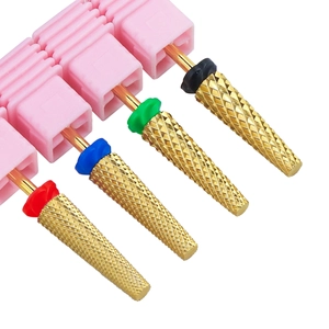 Close-up of four alloy nail drill bits with color rings on a pink plastic base