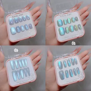 Detail view of handmade cat-eye press-on nails in four styles within a pink display box