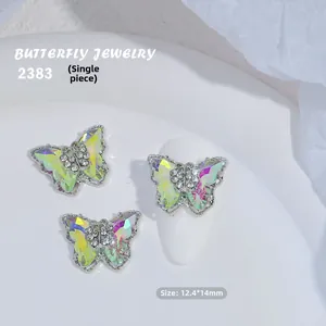 Detalle de decoración de uñas mariposa de cristal 3D con acabado irisado y metal