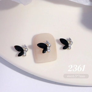 Close-up of 6.5x7mm black crystal butterfly nail charm with silver metal and clear rhinestones