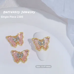 Vista detallada de joya para uñas de mariposa de cristal rosa con bordes dorados y circón