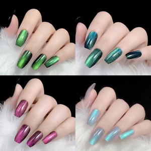 Cat eye press-on nails in green, purple and blue displayed on white faux fur background