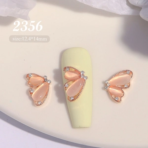 Détail macro d'un bijou d'ongle papillon 12,4x14mm avec œil de chat rose et strass