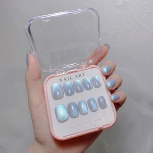 Detail of aurora blue cat-eye glitter press-on nails set in a pink storage box