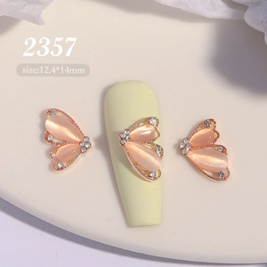 Détail macro du bijou d'ongle papillon 2357 en œil de chat rose avec strass brillants
