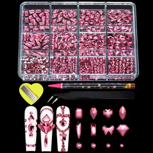 Macro view of 12-grid nail art kit with pink rhinestones, wax pencil and tweezers set