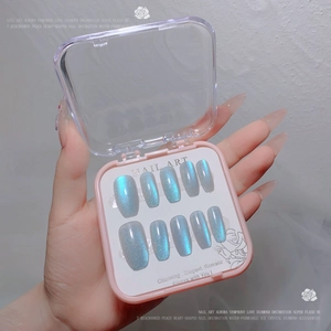 Close-up of aurora blue glitter gradient press-on nails in a pink display case
