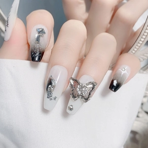 Exquisitas uñas press-on degradadas en blanco y negro con cristales de mariposa 3D y gemas