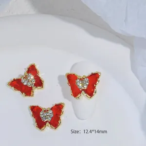 Decoración de uñas mariposa esmaltada roja con cristales de circón y bordes dorados