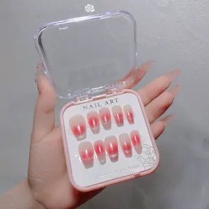Pink gradient cat-eye press-on nails set with glitter tips in a transparent display box
