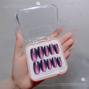Detail of purple cat eye press-on nails with sparkling diamond finish in storage box