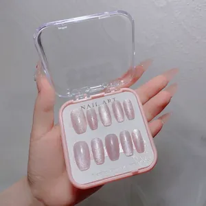 Detail of pink cat-eye press-on nails in long coffin shape with a luxury storage box