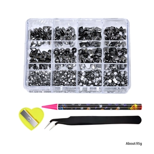 Flatback black nail rhinestones set with mixed shapes, tweezers, and dotting pen tools