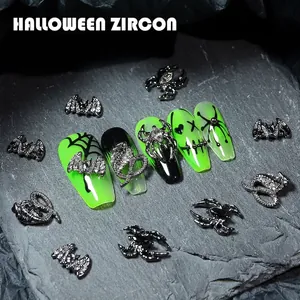 Gothic punk Halloween nail charms featuring bats, spiders, and snakes on stone background
