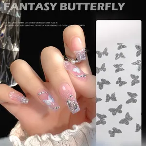 Detailed view of silver glitter butterfly nail charms on pink gel manicured nails