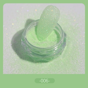 Macro shot of mint green glitter nail powder with holographic shimmer effect and swatch