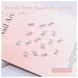 Detailed macro view of a 8x4mm white ballet bow nail art charm with a center pearl bead