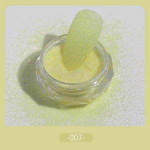 Macro shot of pale yellowish-green fine nail glitter powder with sugar coating effect