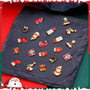 Close-up of alloy Christmas nail charms featuring snowman and bell designs with rhinestones