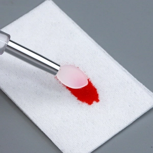 Close-up of silicone nail art brush tip applying chrome powder onto a soft surface
