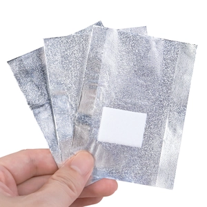 Close-up of nail foil wraps with cotton pads for gel polish removal held in hand