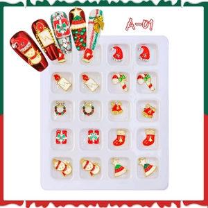 Macro detail of Christmas nail art charms set including bells and snowmen in 20-grid tray