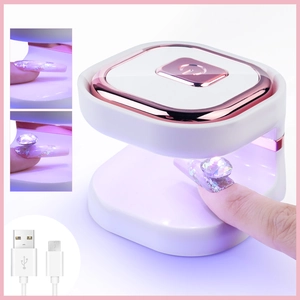 Detail view of mini UV LED nail lamp with rose gold trim and USB power cable for gel polish