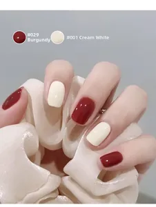 Glossy nail polish set showing dark red and creamy white colors on manicured nails