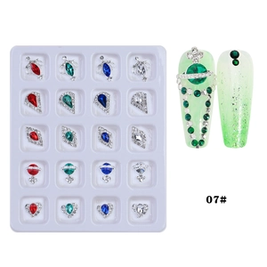 Macro detail of mixed alloy nail charms including planet and heart shapes in a display box
