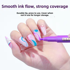 Close-up of purple nail art pen drawing fine patterns on a decorated nail tip