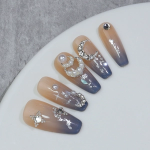 Détail macro d'ongles ombrés avec décorations de lune en perles et zircone