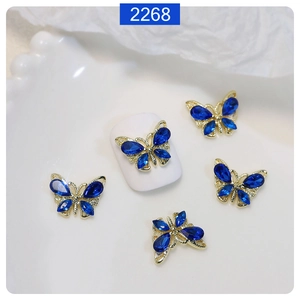 Close-up of 3D gold alloy butterfly nail charms with deep blue crystal water drop rhinestones