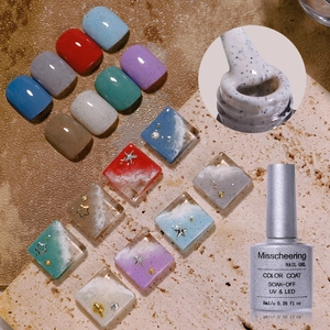 Macro view of sea salt grain nail gel polish with starfish and shell 3D beach nail art